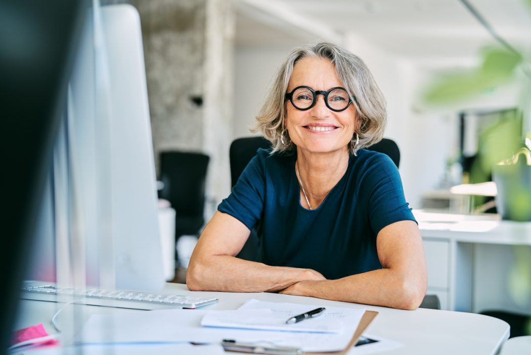 smiling-businesswoman-at-desk-in-office-2