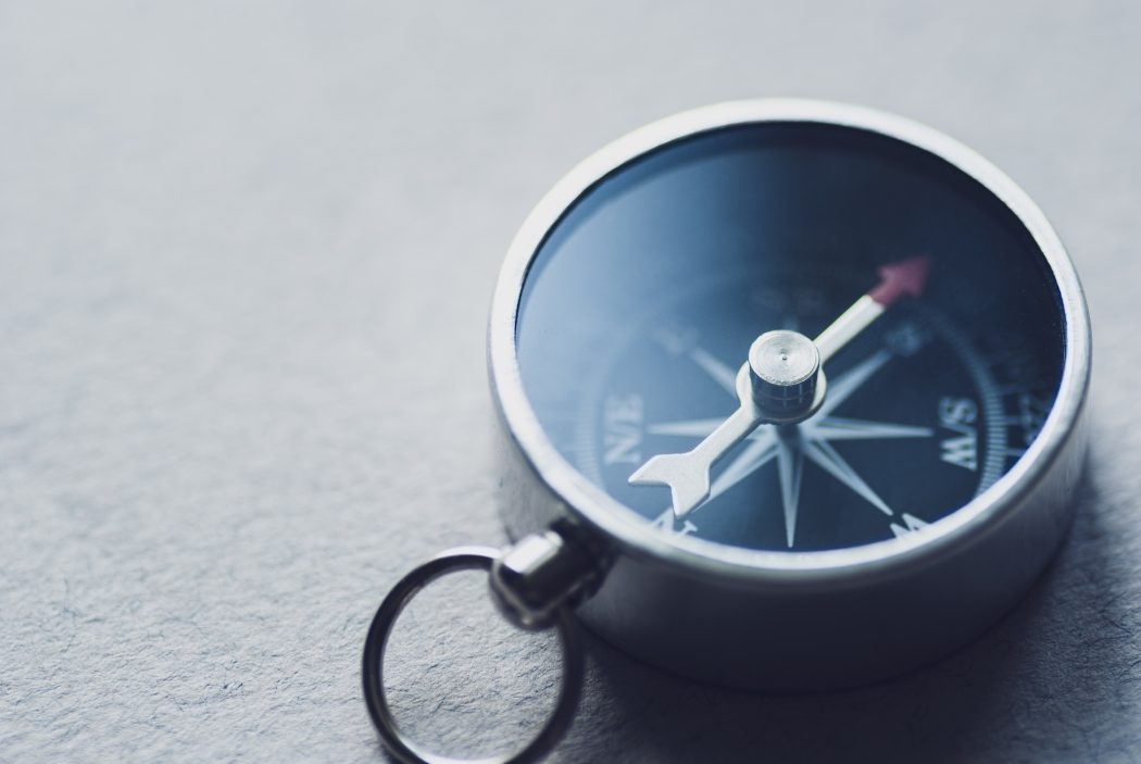 small-magnetic-compass-on-a-grey-background